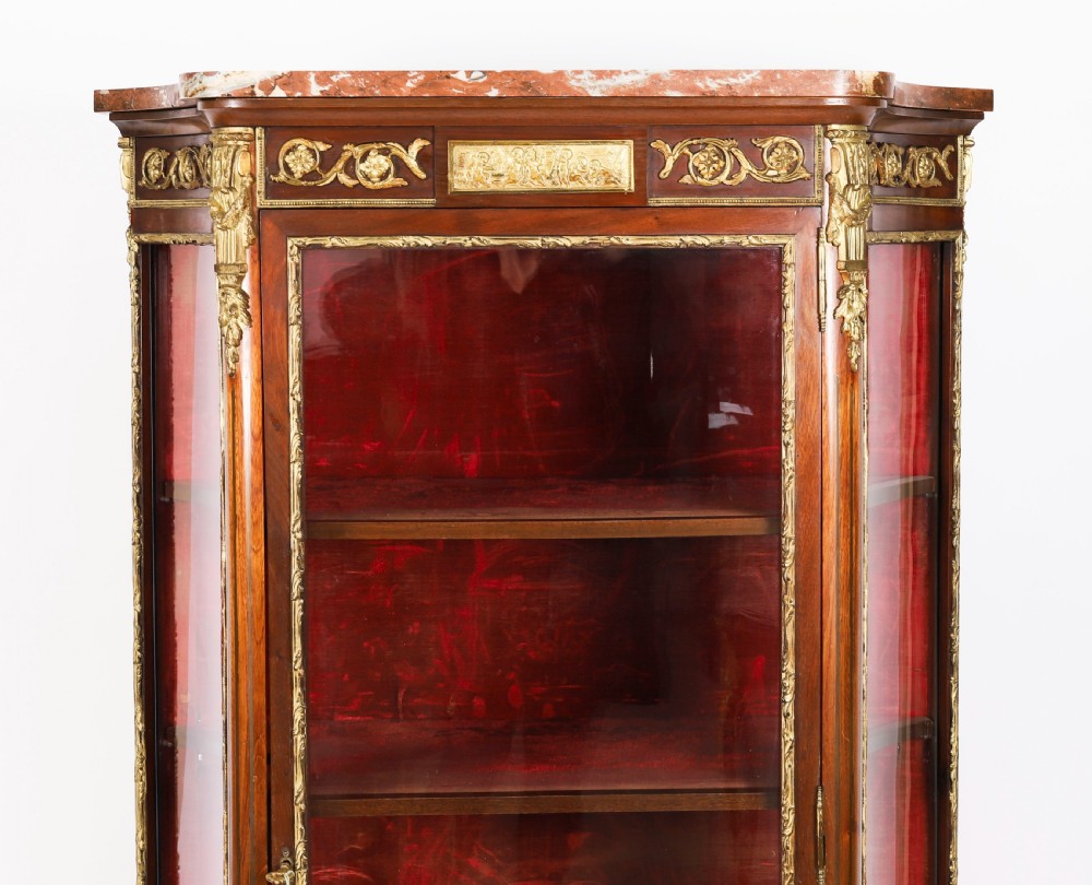 A 19th-century French Louis Revival vitrine cabinet featuring a marble top, glazed glass sides and door, floral marquetry panels, and ornate gilt bronze mounts. View VII