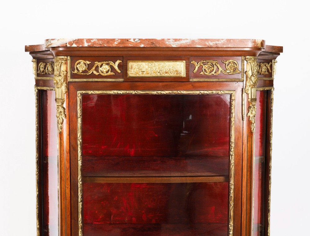 A 19th-century French Louis Revival vitrine cabinet featuring a marble top, glazed glass sides and door, floral marquetry panels, and ornate gilt bronze mounts. View VIII