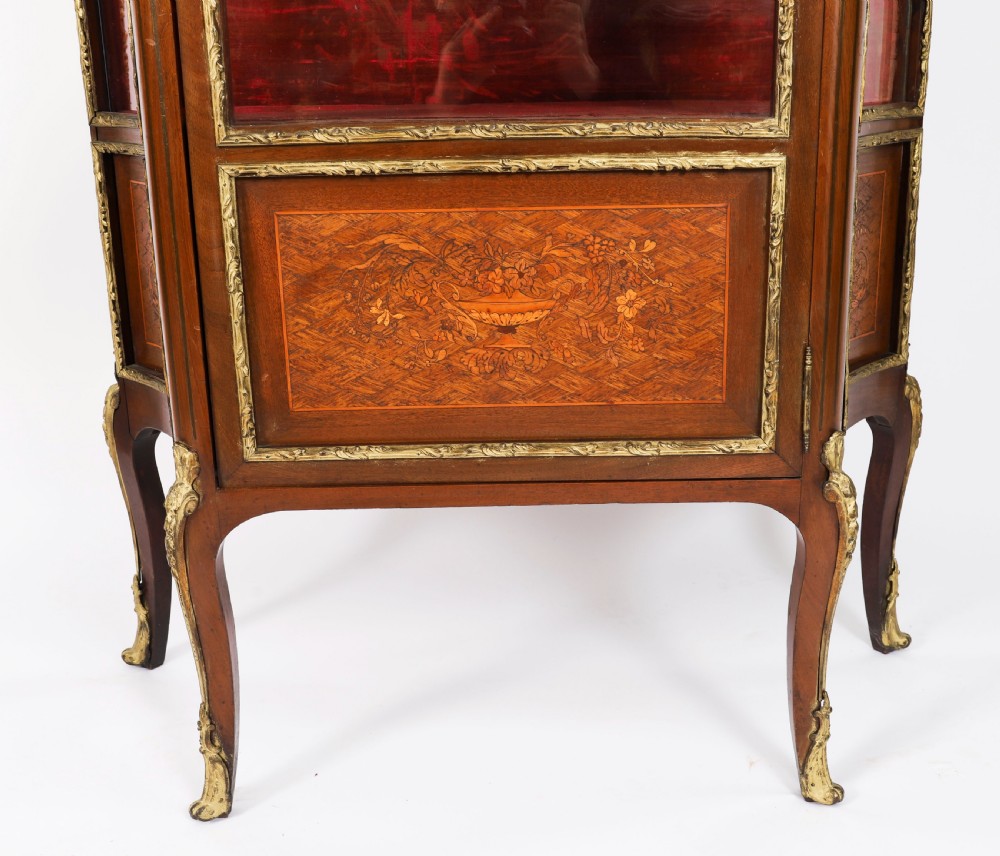A 19th-century French Louis Revival vitrine cabinet featuring a marble top, glazed glass sides and door, floral marquetry panels, and ornate gilt bronze mounts. View XIII