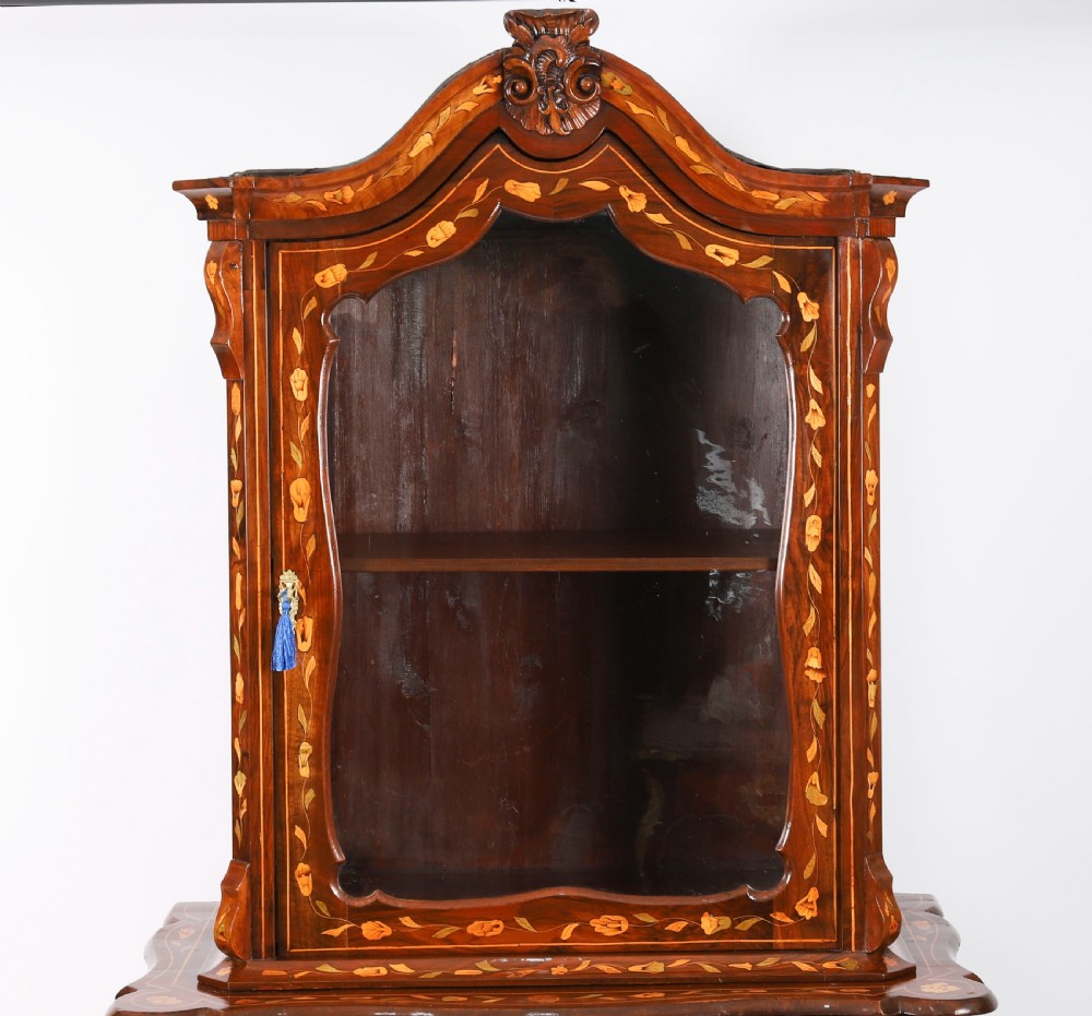 An 18th-century Dutch walnut cabinet on chest featuring detailed floral marquetry inlay, an arched bonnet top with glass doors, and four brass-handled drawers. View V