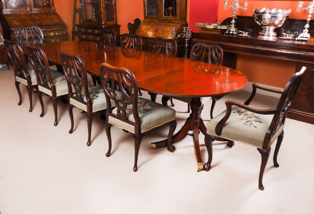 A large George IV Regency mahogany extended dining table featuring three pedestal supports with reeded legs and brass castors. View II