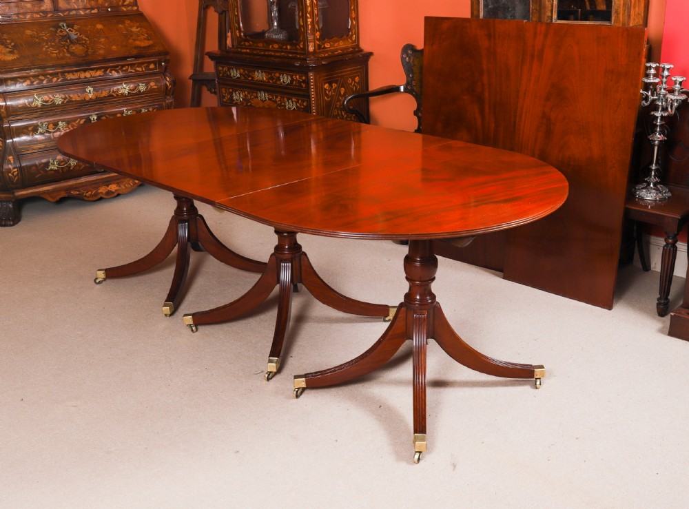 A large George IV Regency mahogany extended dining table featuring three pedestal supports with reeded legs and brass castors. View VII