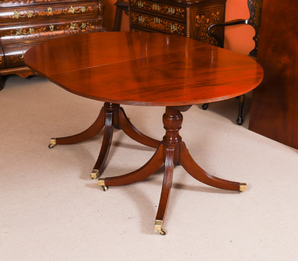 A large George IV Regency mahogany extended dining table featuring three pedestal supports with reeded legs and brass castors. View VIII