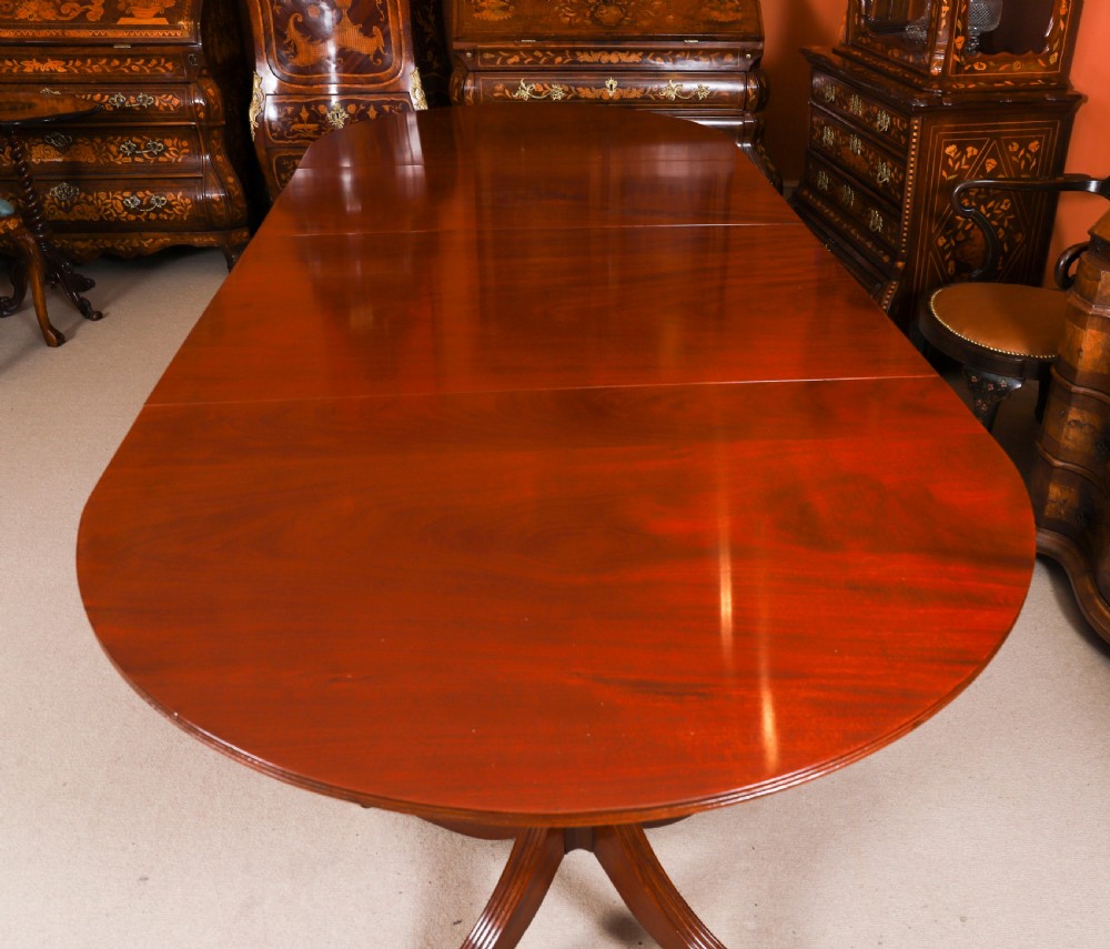 A large George IV Regency mahogany extended dining table featuring three pedestal supports with reeded legs and brass castors. View XII