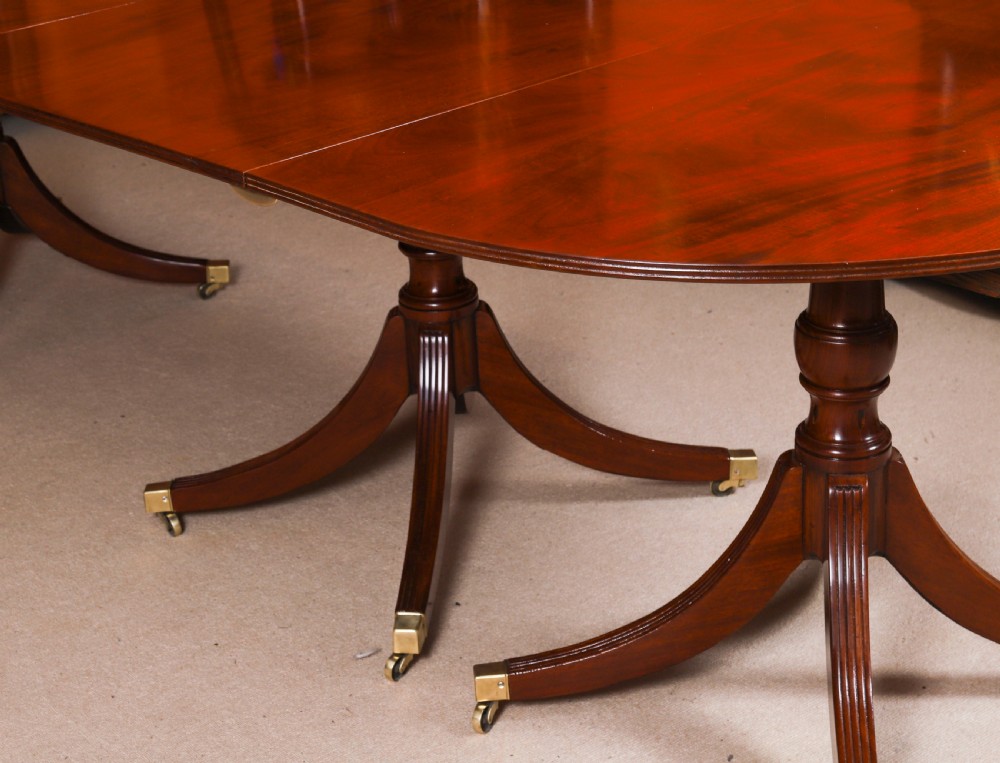 A large George IV Regency mahogany extended dining table featuring three pedestal supports with reeded legs and brass castors. View XIV