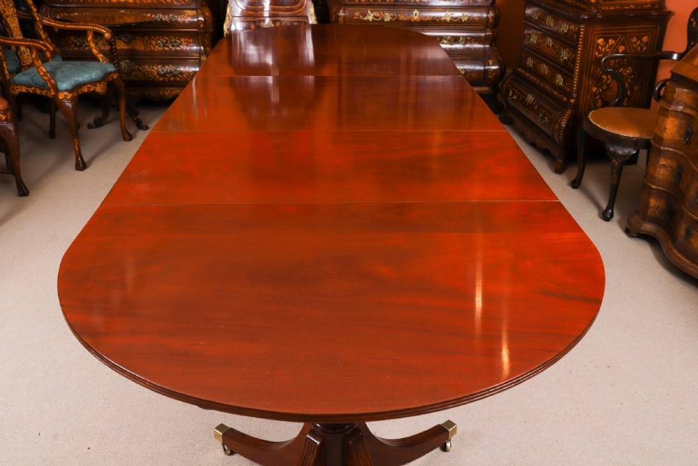 A large George IV Regency mahogany extended dining table featuring three pedestal supports with reeded legs and brass castors. View XVII
