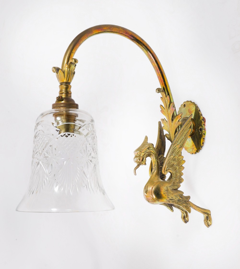 A set of six Neo-Classical brass wall sconces featuring sculpted griffin mounts, curved arms, and flared cut-glass bell shades. View II