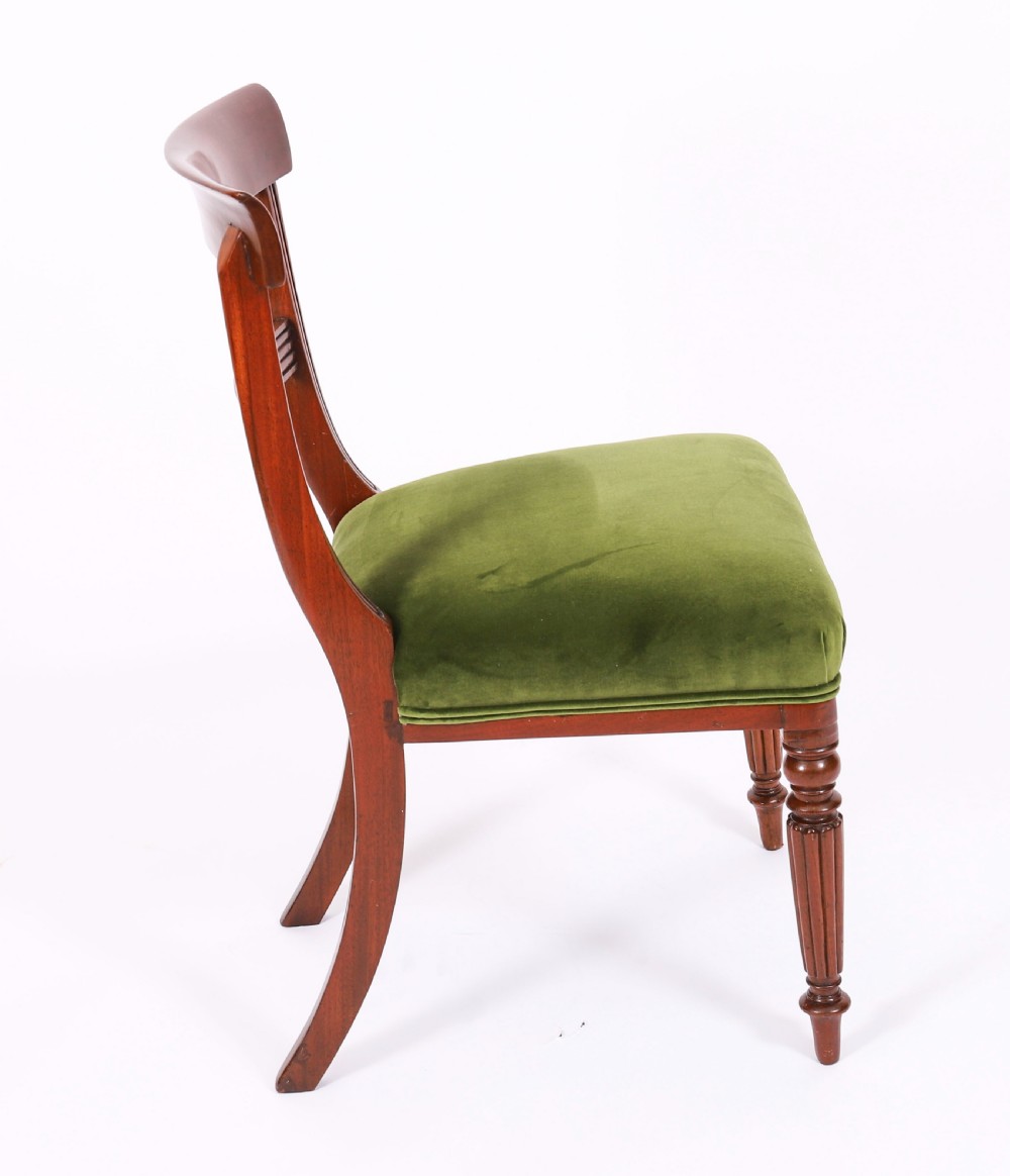 A set of six Regency mahogany dining chairs featuring curved bar top rails, reeded front legs, and green velvet seats. View III