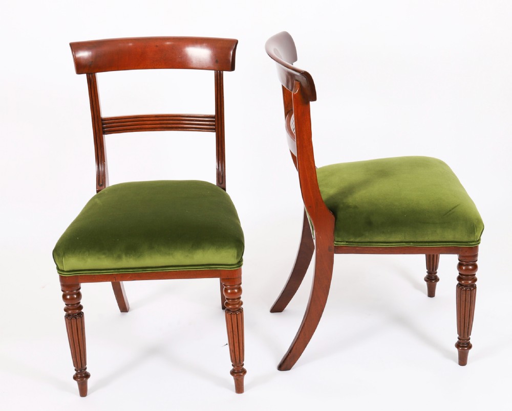 A set of six Regency mahogany dining chairs featuring curved bar top rails, reeded front legs, and green velvet seats. View V
