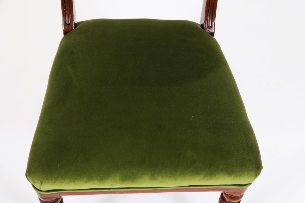 A set of six Regency mahogany dining chairs featuring curved bar top rails, reeded front legs, and green velvet seats. View VI