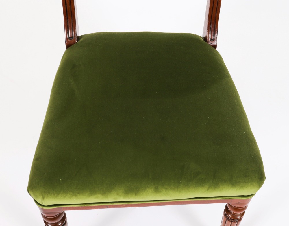 A set of six Regency mahogany dining chairs featuring curved bar top rails, reeded front legs, and green velvet seats. View VII