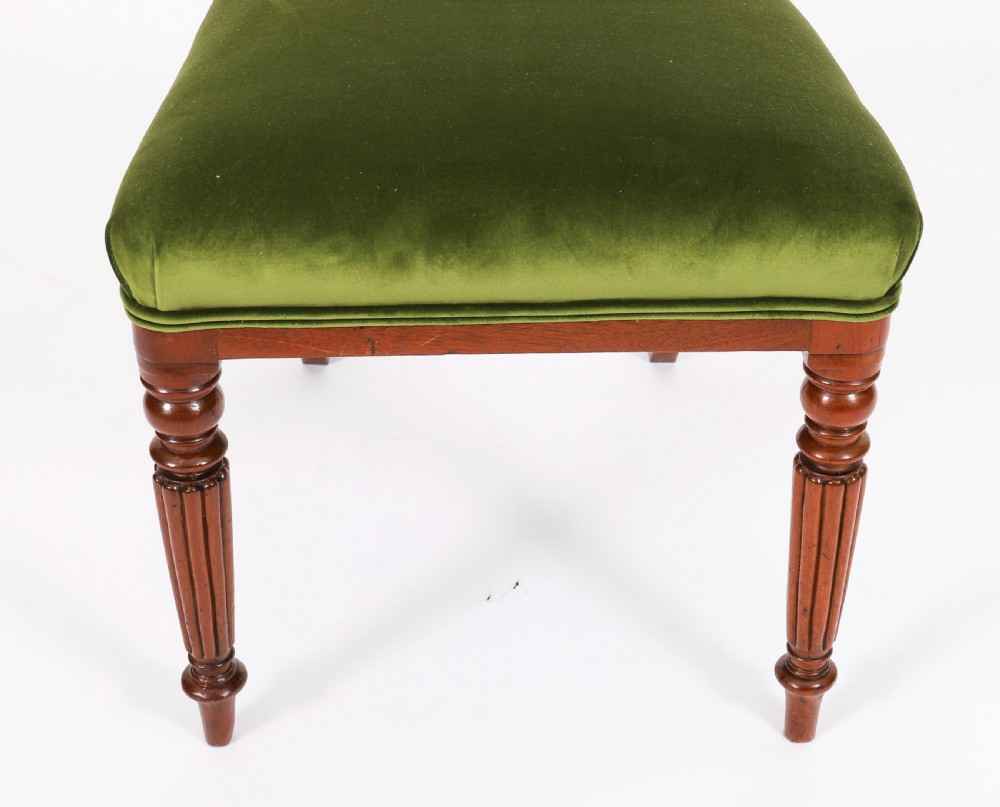 A set of six Regency mahogany dining chairs featuring curved bar top rails, reeded front legs, and green velvet seats. View VIII