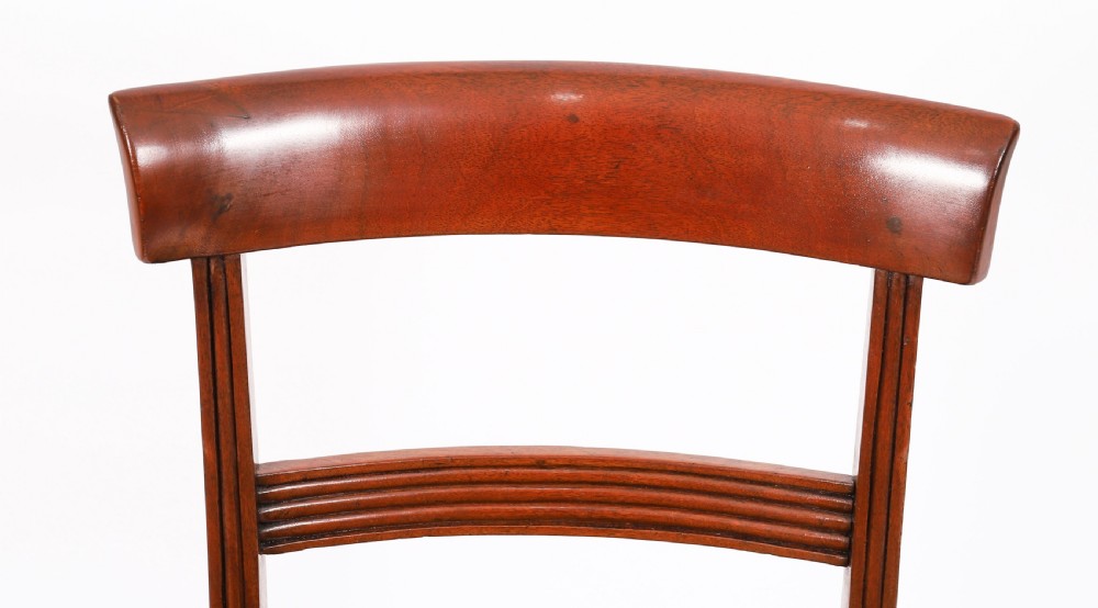 A set of six Regency mahogany dining chairs featuring curved bar top rails, reeded front legs, and green velvet seats. View IX