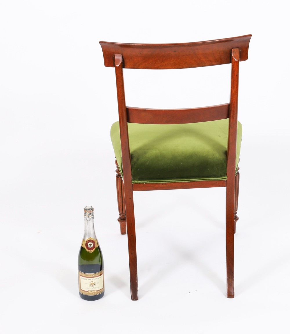 A set of six Regency mahogany dining chairs featuring curved bar top rails, reeded front legs, and green velvet seats. View XII