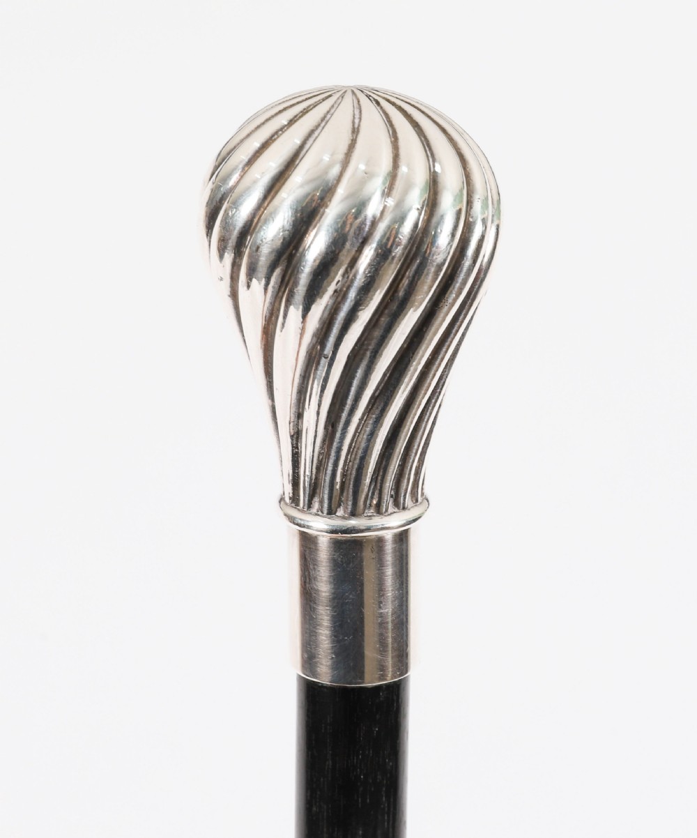 An antique French walking cane featuring a black ebonised shaft and a silver-plated fluted pommel handle. View IV
