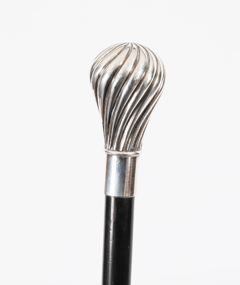 An antique French walking cane featuring a black ebonised shaft and a silver-plated fluted pommel handle. View VI