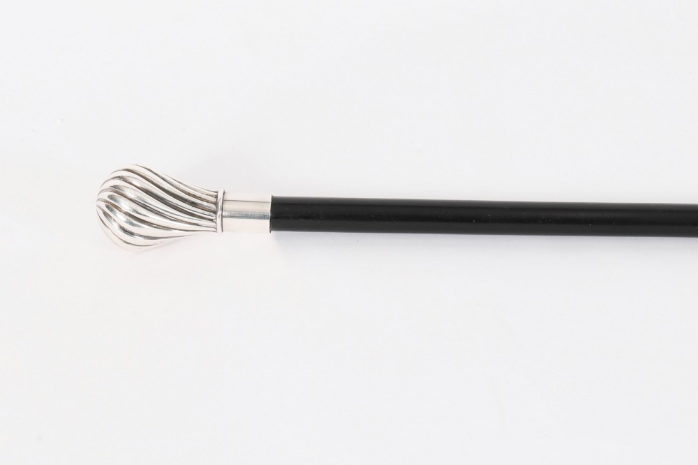 An antique French walking cane featuring a black ebonised shaft and a silver-plated fluted pommel handle. View VIII