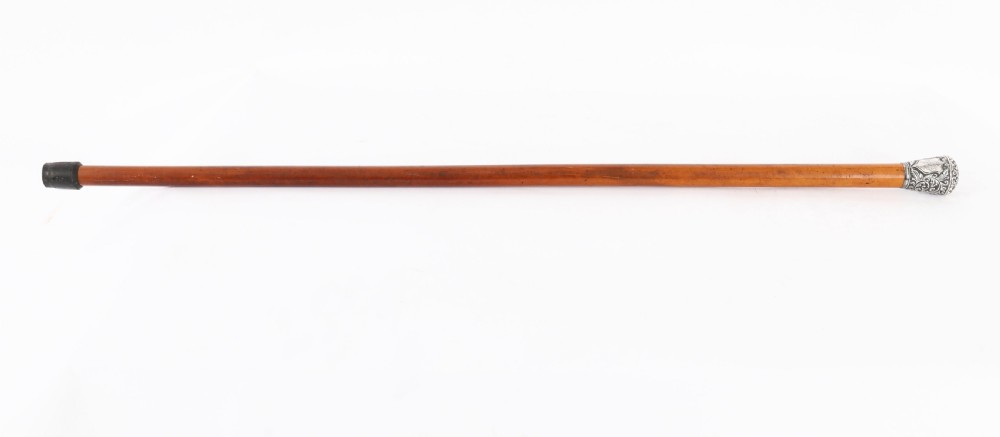 An antique walking stick featuring an elaborately chased silver pommel handle with foliate motifs mounted on a smooth light timber shaft. View II