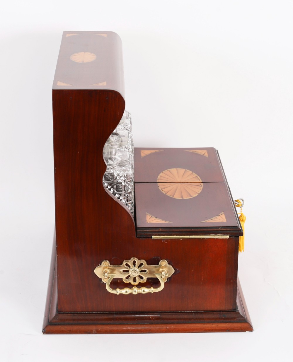 A 19th-century inlaid satinwood and mahogany tantalus containing three cut crystal decanters with faceted stoppers, a mirrored back interior, and a lower fold-out compartment with oval marquetry paterae. View VII