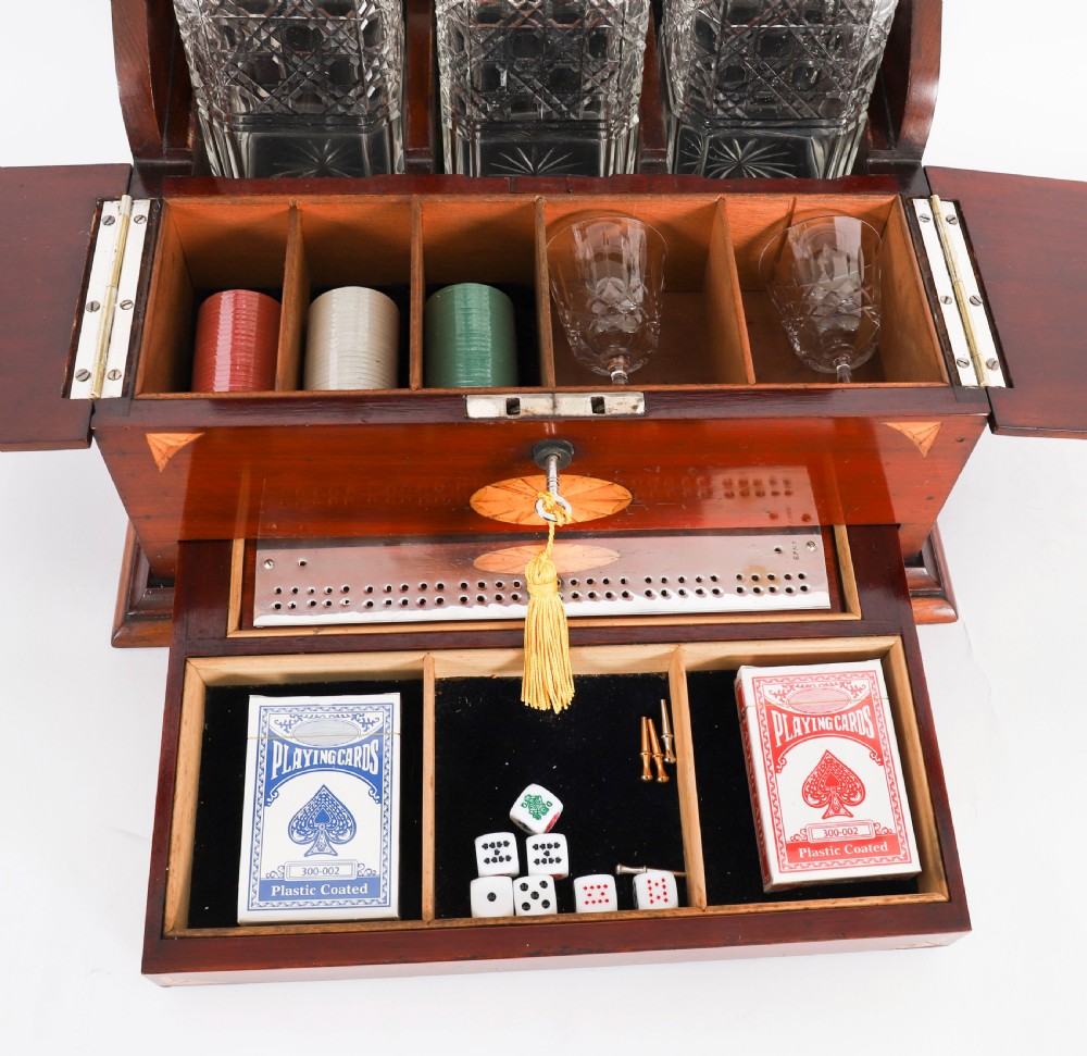 A 19th-century inlaid satinwood and mahogany tantalus containing three cut crystal decanters with faceted stoppers, a mirrored back interior, and a lower fold-out compartment with oval marquetry paterae. View XIII