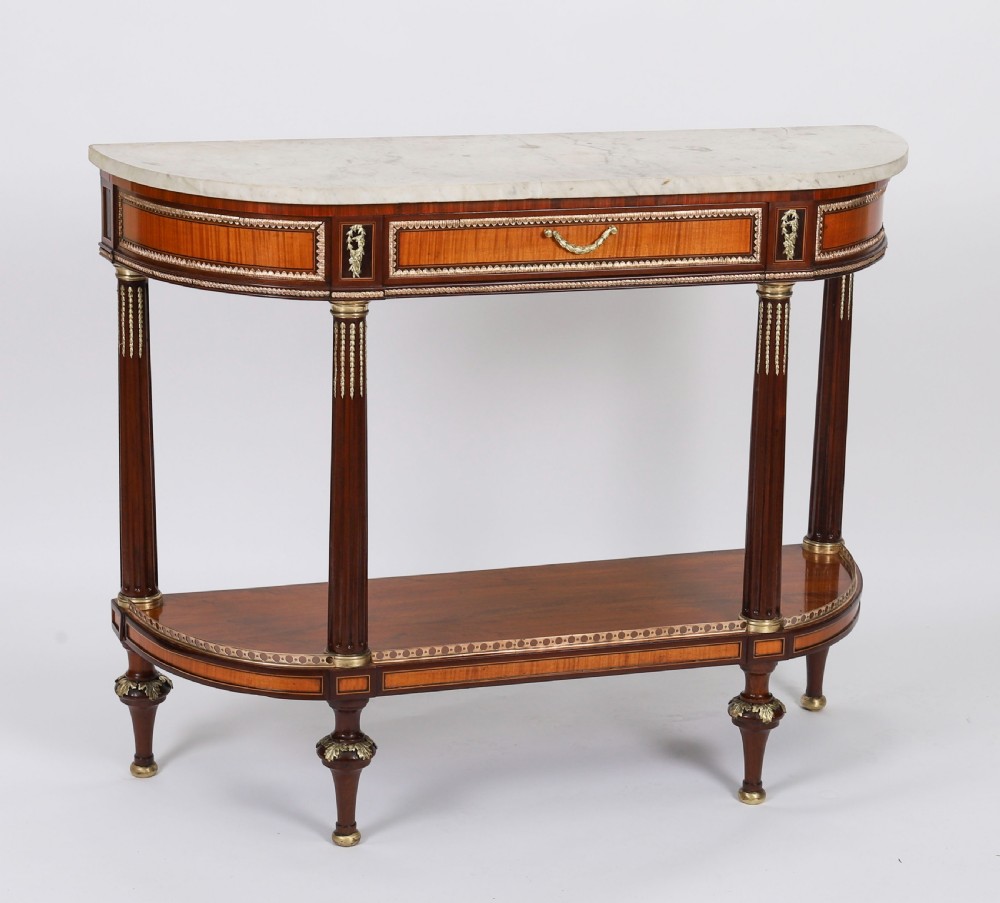 A pair of 19th-century French Louis XVI style demi-lune console tables with white Carrara marble tops, gilt bronze mounts, fluted legs, and undershelves. View II