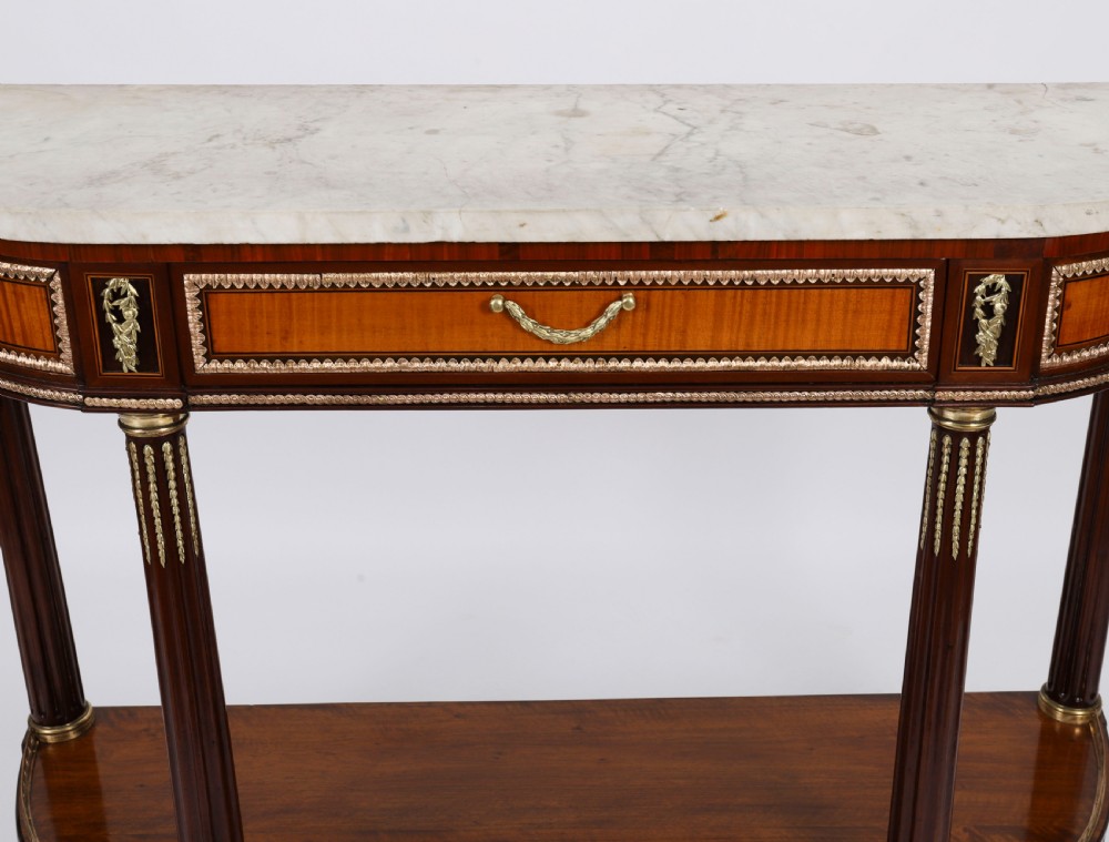 A pair of 19th-century French Louis XVI style demi-lune console tables with white Carrara marble tops, gilt bronze mounts, fluted legs, and undershelves. View VI