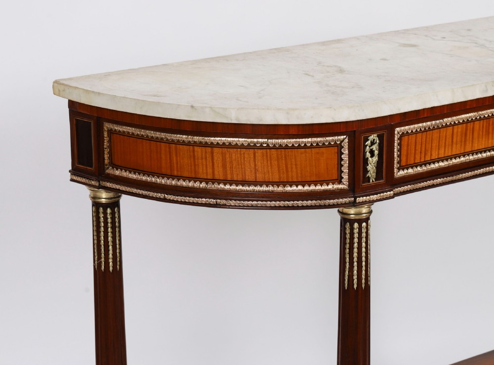 A pair of 19th-century French Louis XVI style demi-lune console tables with white Carrara marble tops, gilt bronze mounts, fluted legs, and undershelves. View VII