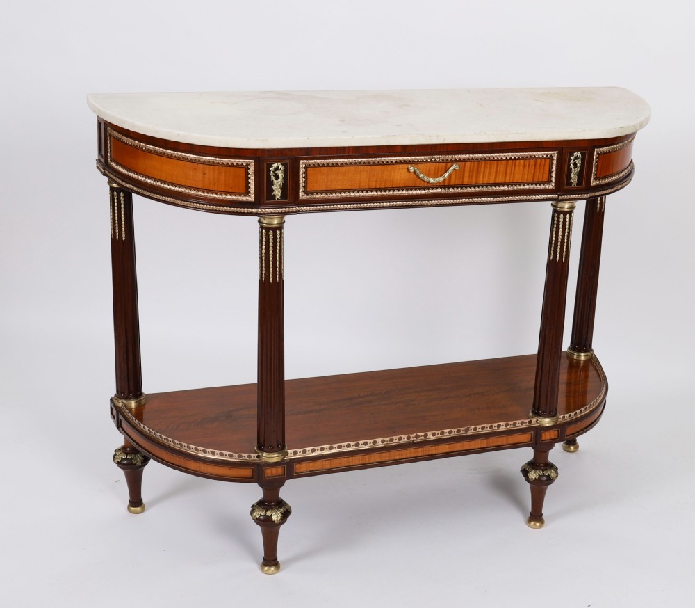 A pair of 19th-century French Louis XVI style demi-lune console tables with white Carrara marble tops, gilt bronze mounts, fluted legs, and undershelves. View XII