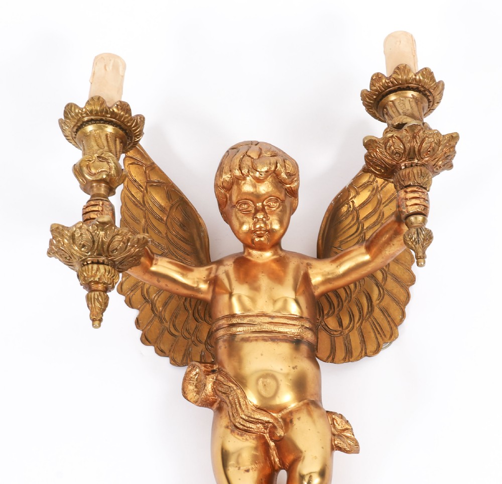 A pair of nineteenth-century gilt metal two-branch wall sconces featuring sculpted winged cherubs holding torch-shaped candleholders. View III