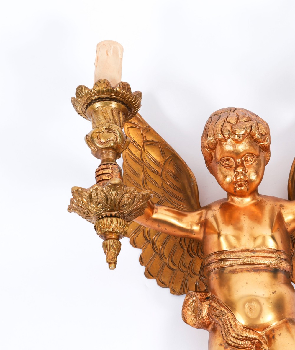 A pair of nineteenth-century gilt metal two-branch wall sconces featuring sculpted winged cherubs holding torch-shaped candleholders. View IV
