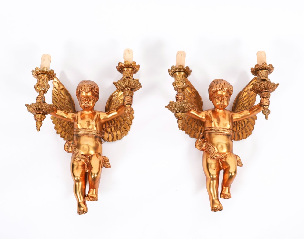 A pair of nineteenth-century gilt metal two-branch wall sconces featuring sculpted winged cherubs holding torch-shaped candleholders. View VIII