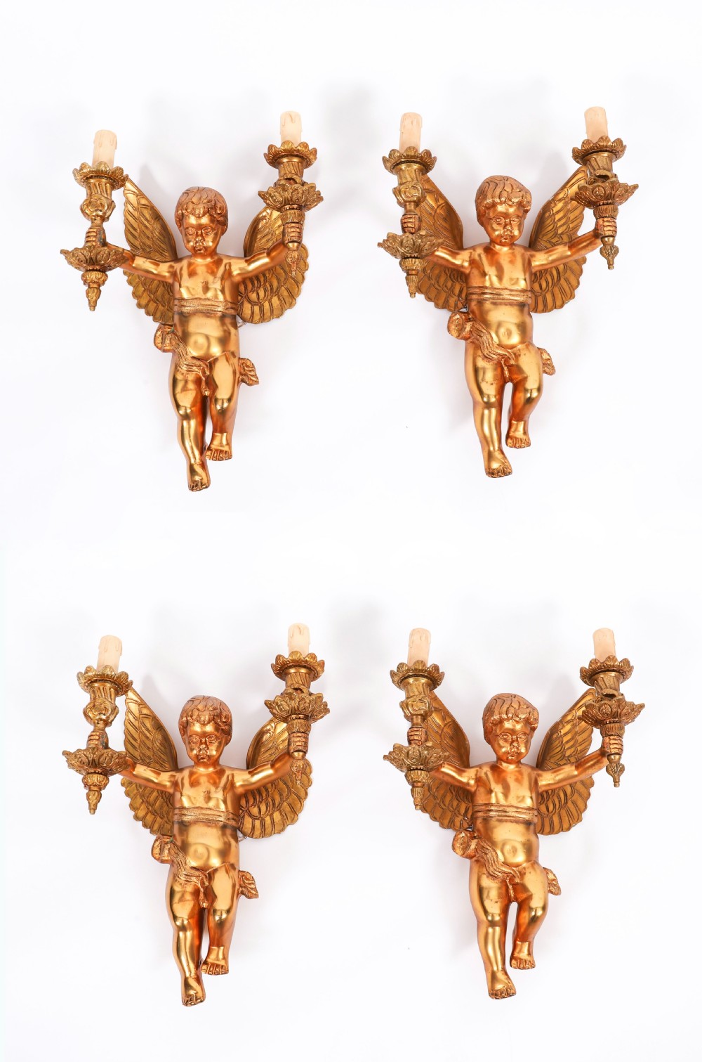 A set of four gilt ormolu two-branch wall sconces sculpted in the form of winged cherubs holding candle holders.