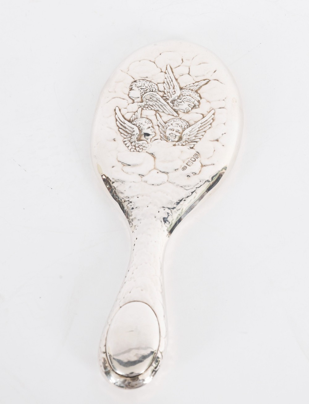 An Edwardian sterling silver hand mirror featuring embossed cherub heads and clouds on the back. View II