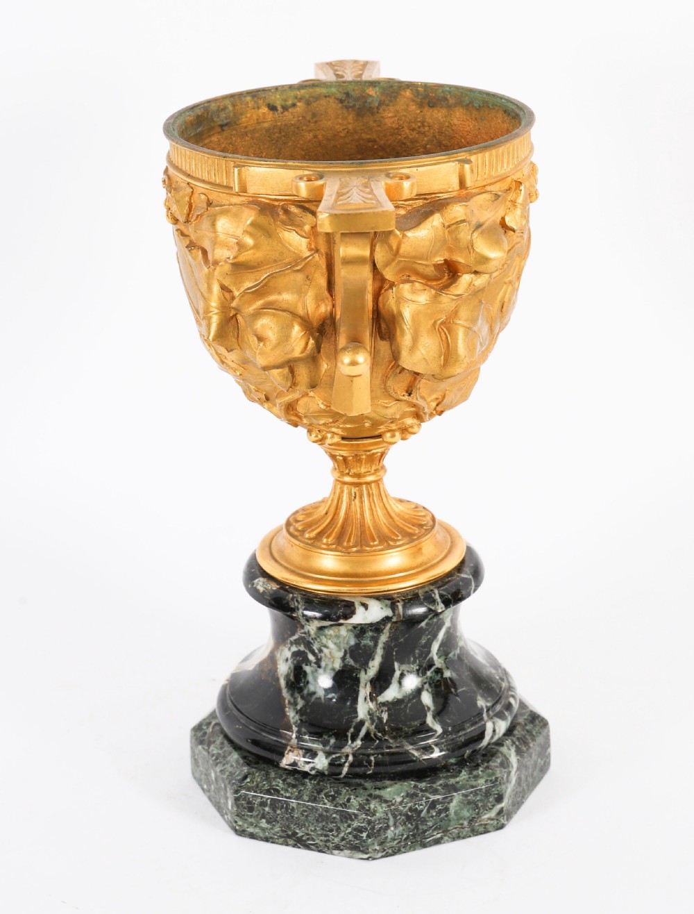 A pair of nineteenth-century French gilt bronze classical urns featuring relief carvings and scroll handles, mounted on dark green marble bases. View VI