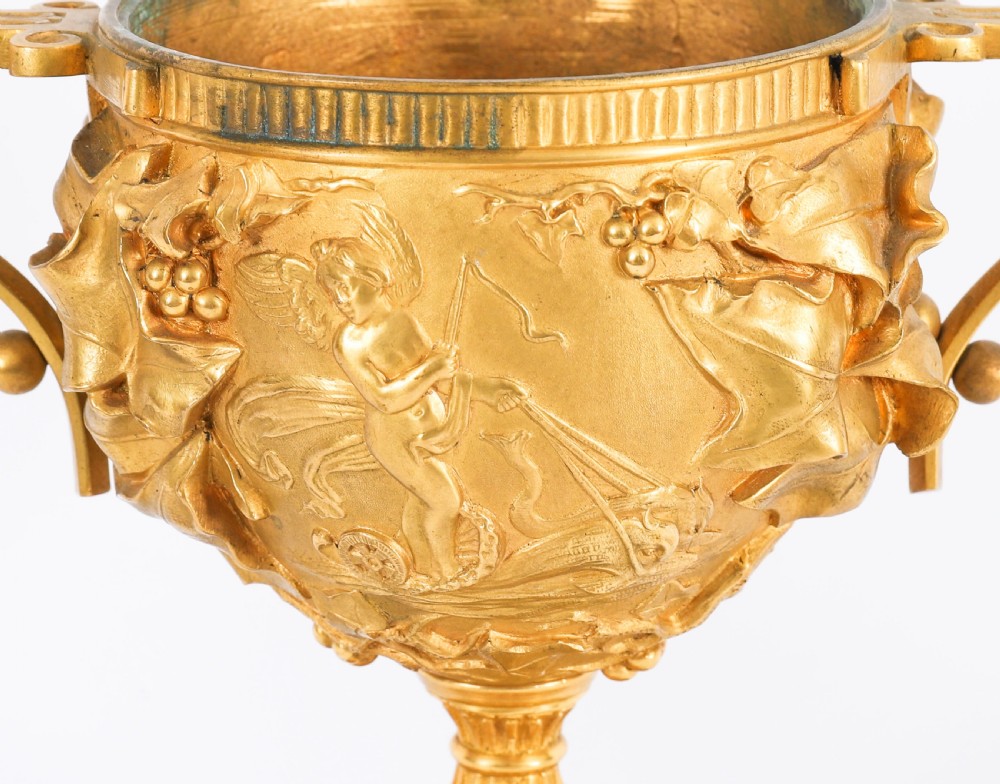 A pair of nineteenth-century French gilt bronze classical urns featuring relief carvings and scroll handles, mounted on dark green marble bases. View XIV