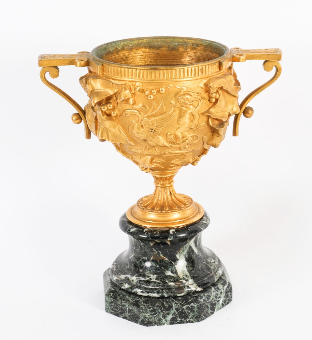 A pair of nineteenth-century French gilt bronze classical urns featuring relief carvings and scroll handles, mounted on dark green marble bases. View XVI