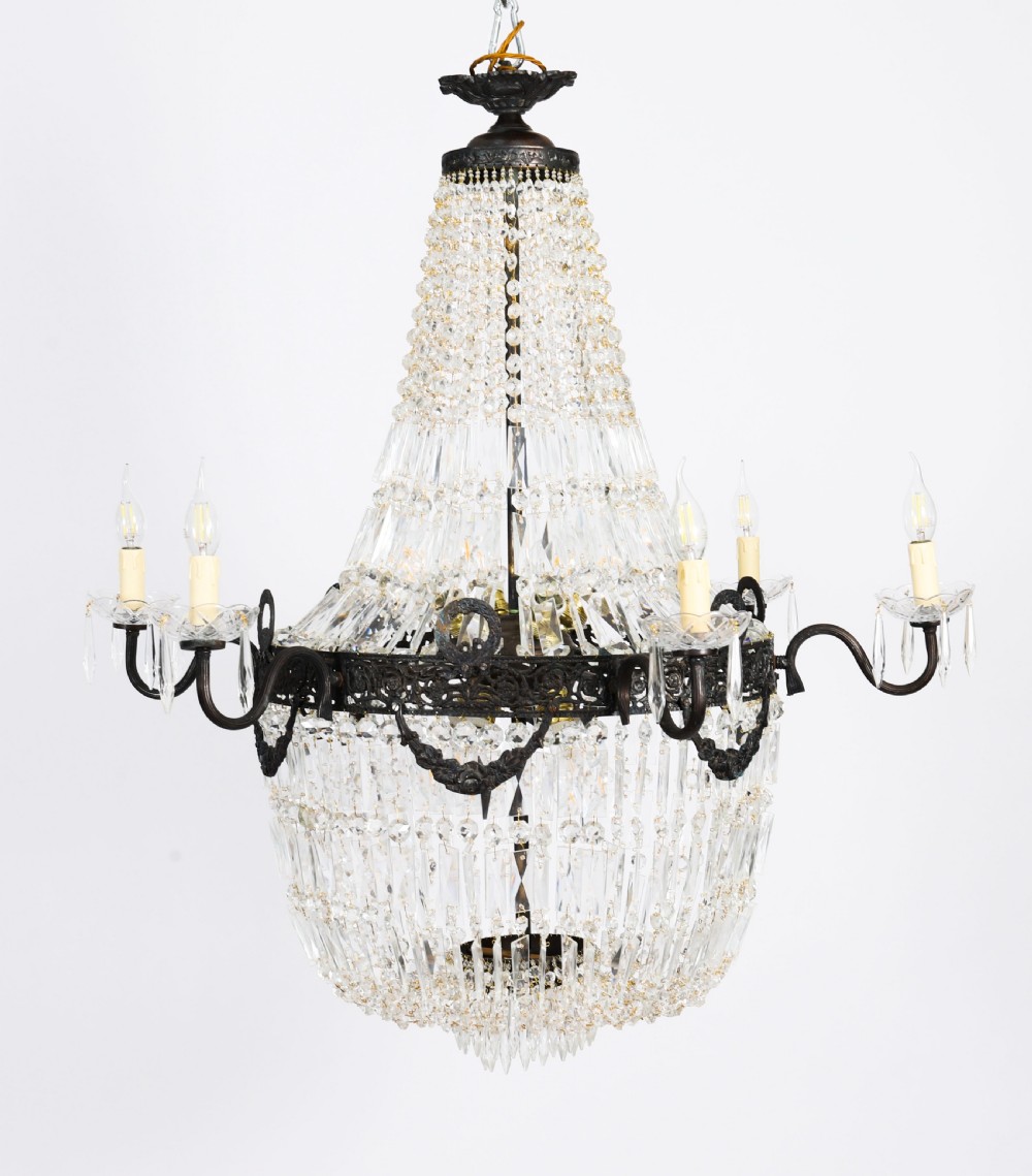 A pair of French Louis Revival tent and bag style chandeliers featuring tiered crystal bead cascades, dark bronze metal bands with floral festoons, and extending candle arms. View V