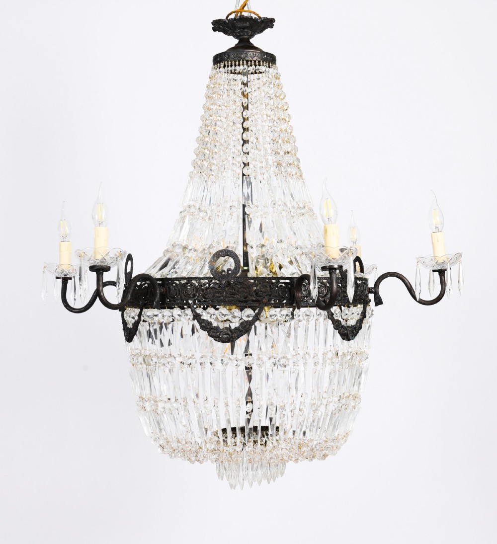 A pair of French Louis Revival tent and bag style chandeliers featuring tiered crystal bead cascades, dark bronze metal bands with floral festoons, and extending candle arms. View XII