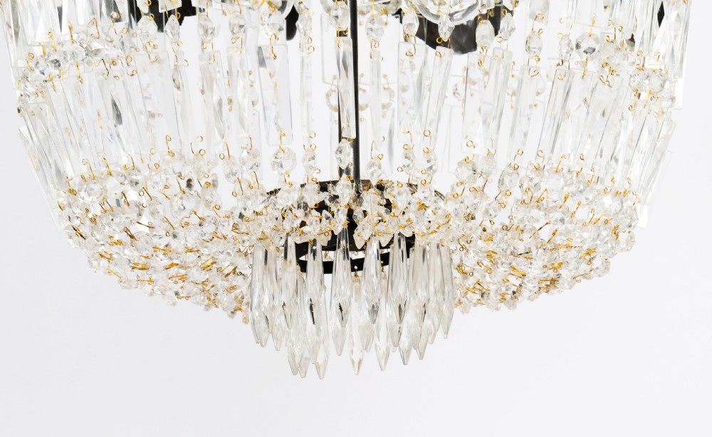 A pair of French Louis Revival tent and bag style chandeliers featuring tiered crystal bead cascades, dark bronze metal bands with floral festoons, and extending candle arms. View XIII