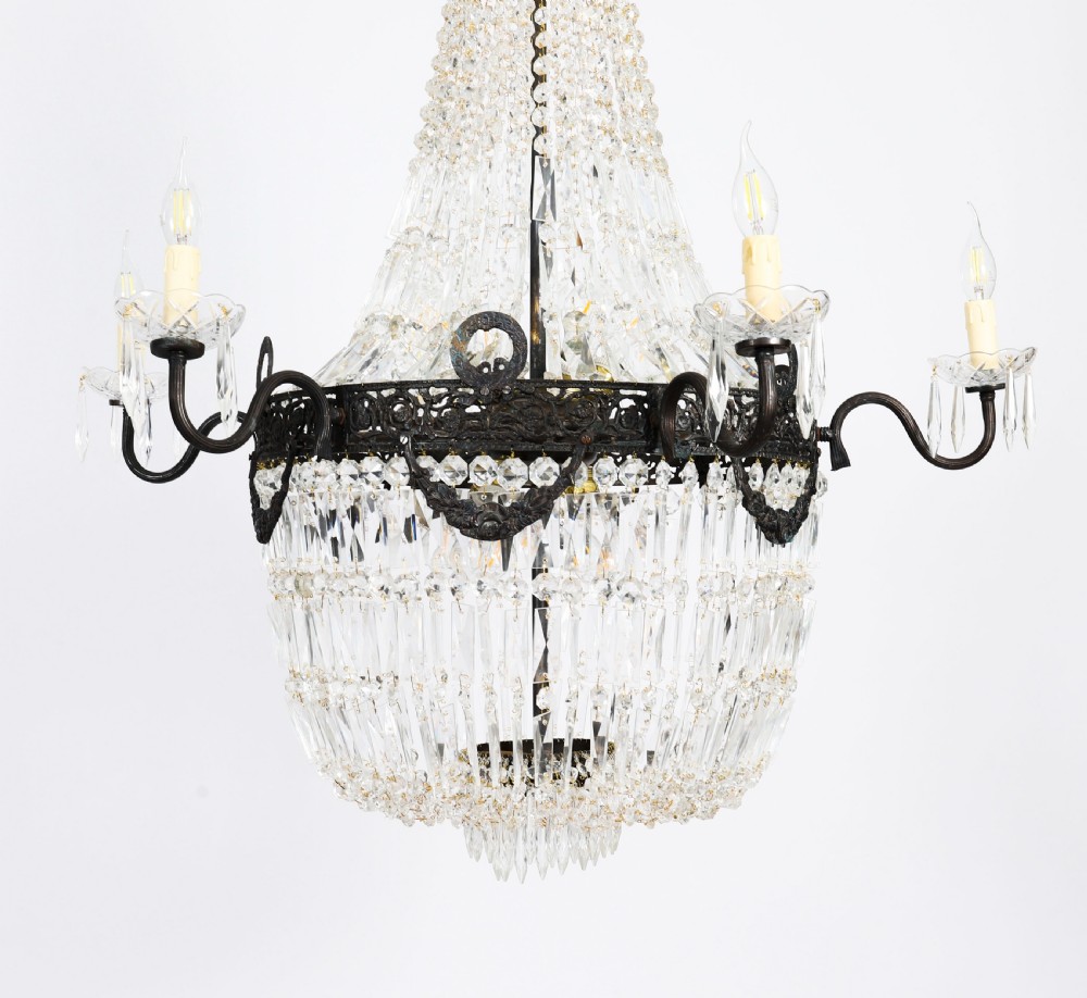 A pair of French Louis Revival tent and bag style chandeliers featuring tiered crystal bead cascades, dark bronze metal bands with floral festoons, and extending candle arms. View XVI