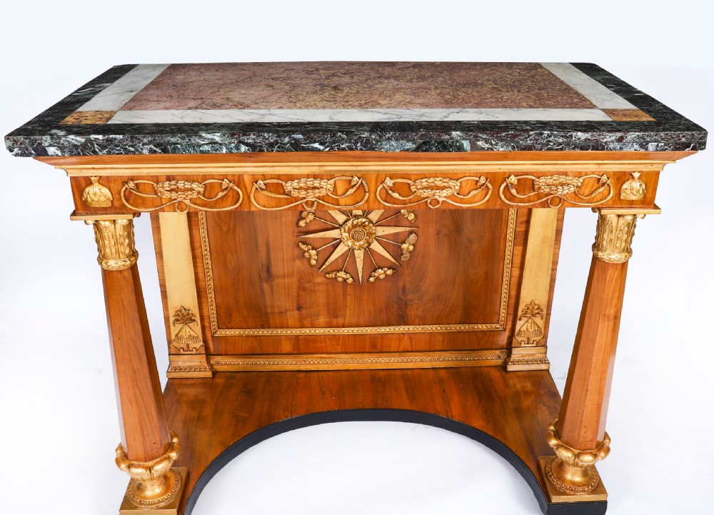 A French Empire walnut console table with a dark marble top, gold parcel gilt column supports, and a starburst motif panel. View III