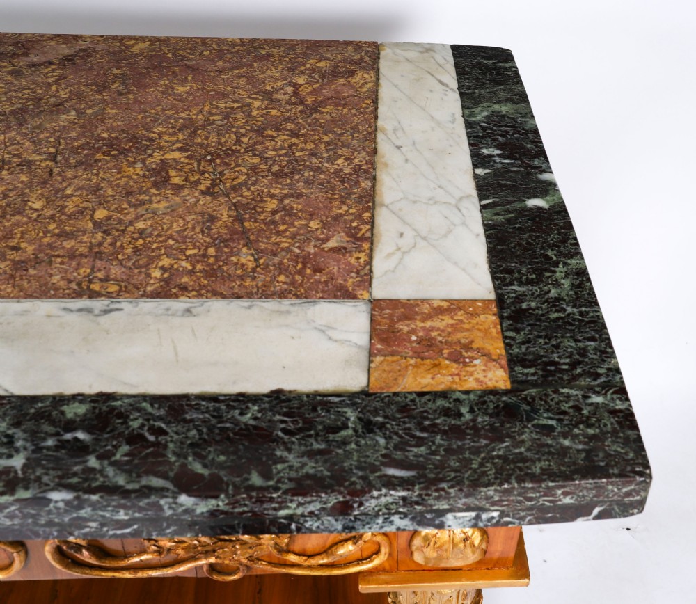 A French Empire walnut console table with a dark marble top, gold parcel gilt column supports, and a starburst motif panel. View VI