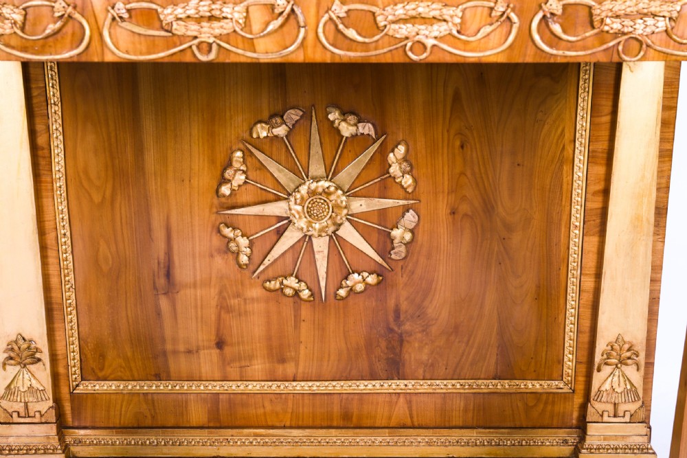 A French Empire walnut console table with a dark marble top, gold parcel gilt column supports, and a starburst motif panel. View XI