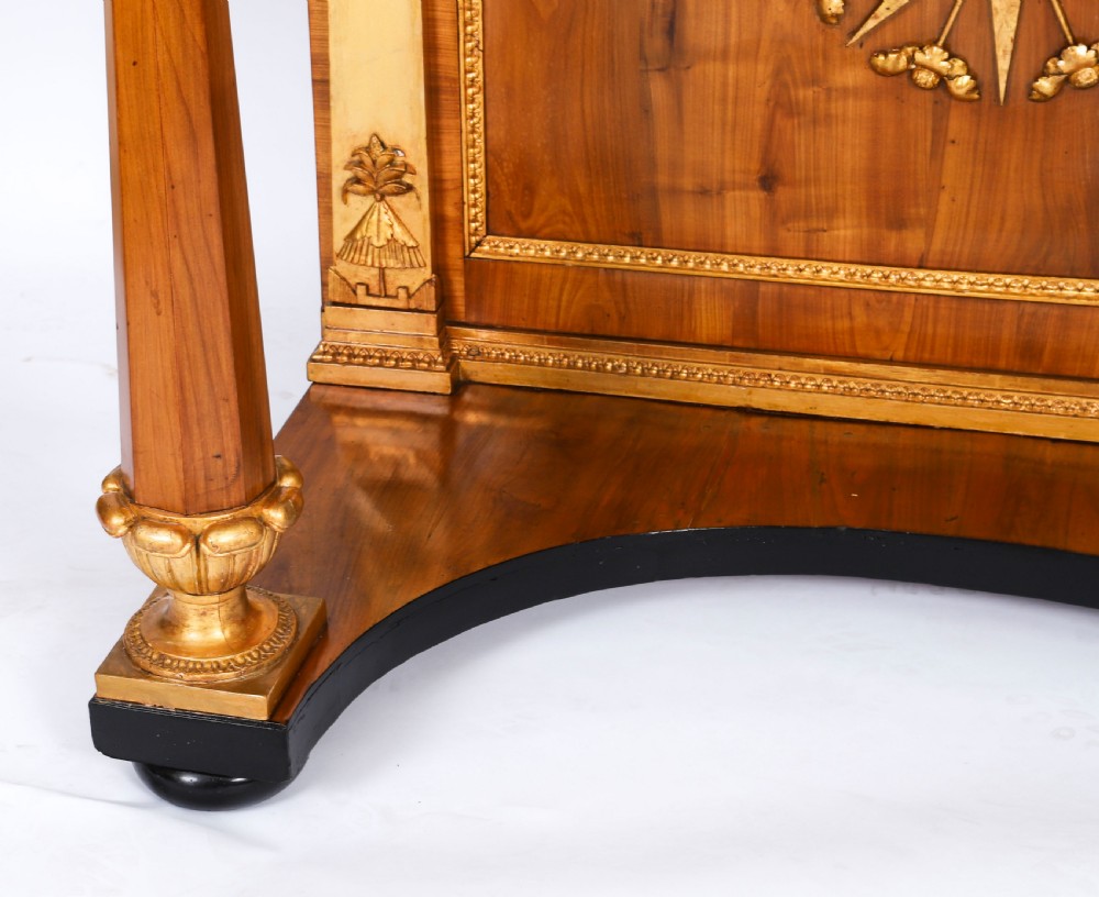 A French Empire walnut console table with a dark marble top, gold parcel gilt column supports, and a starburst motif panel. View XIII