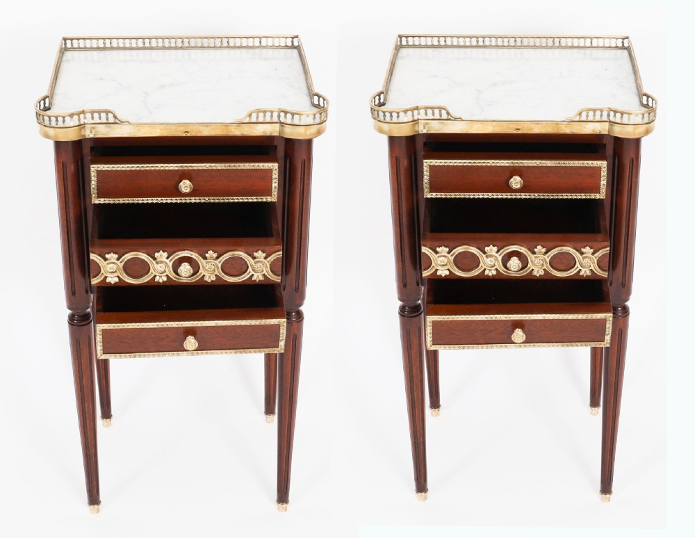A pair of 19th-century mahogany French Empire bedside cabinets featuring white marble tops with pierced brass galleries, gilt bronze mounts, and slender fluted legs. View III