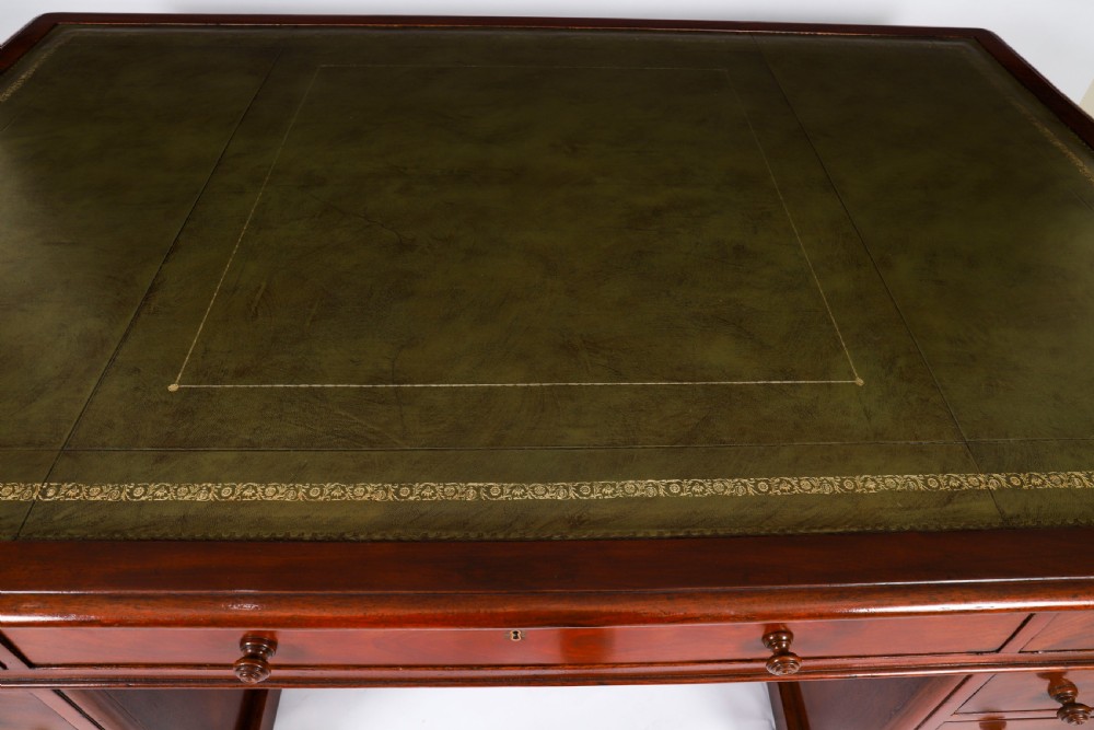 A Victorian flame mahogany partners pedestal desk fitted with a green leather inset top and wooden knob drawer pulls. View II