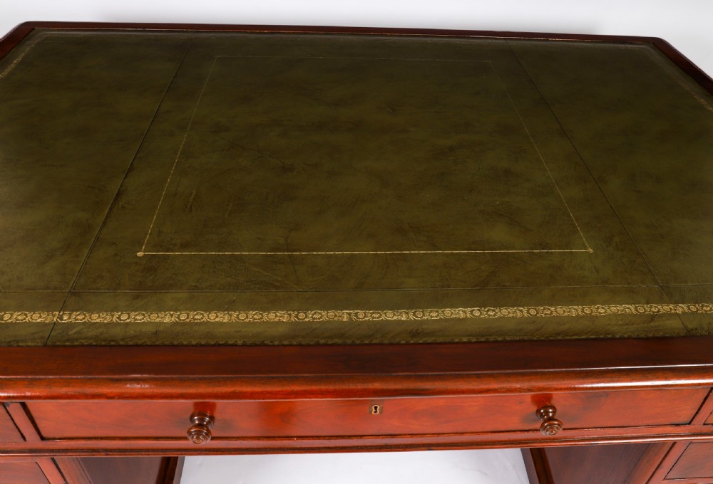 A Victorian flame mahogany partners pedestal desk fitted with a green leather inset top and wooden knob drawer pulls. View III