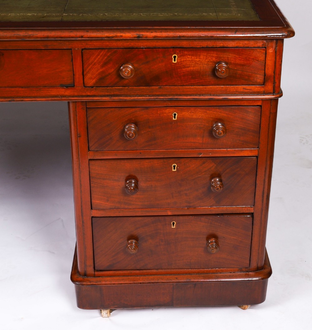 A Victorian flame mahogany partners pedestal desk fitted with a green leather inset top and wooden knob drawer pulls. View IX