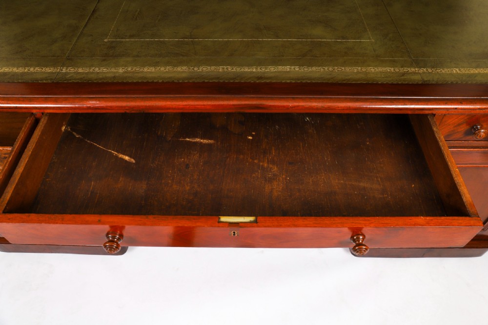 A Victorian flame mahogany partners pedestal desk fitted with a green leather inset top and wooden knob drawer pulls. View XI
