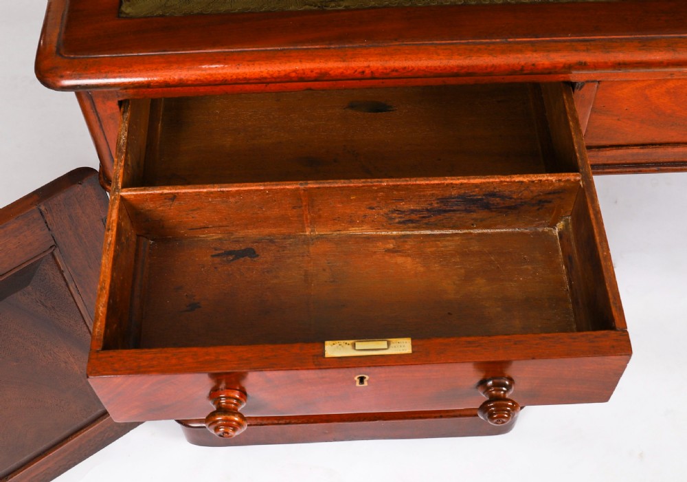 A Victorian flame mahogany partners pedestal desk fitted with a green leather inset top and wooden knob drawer pulls. View XIII